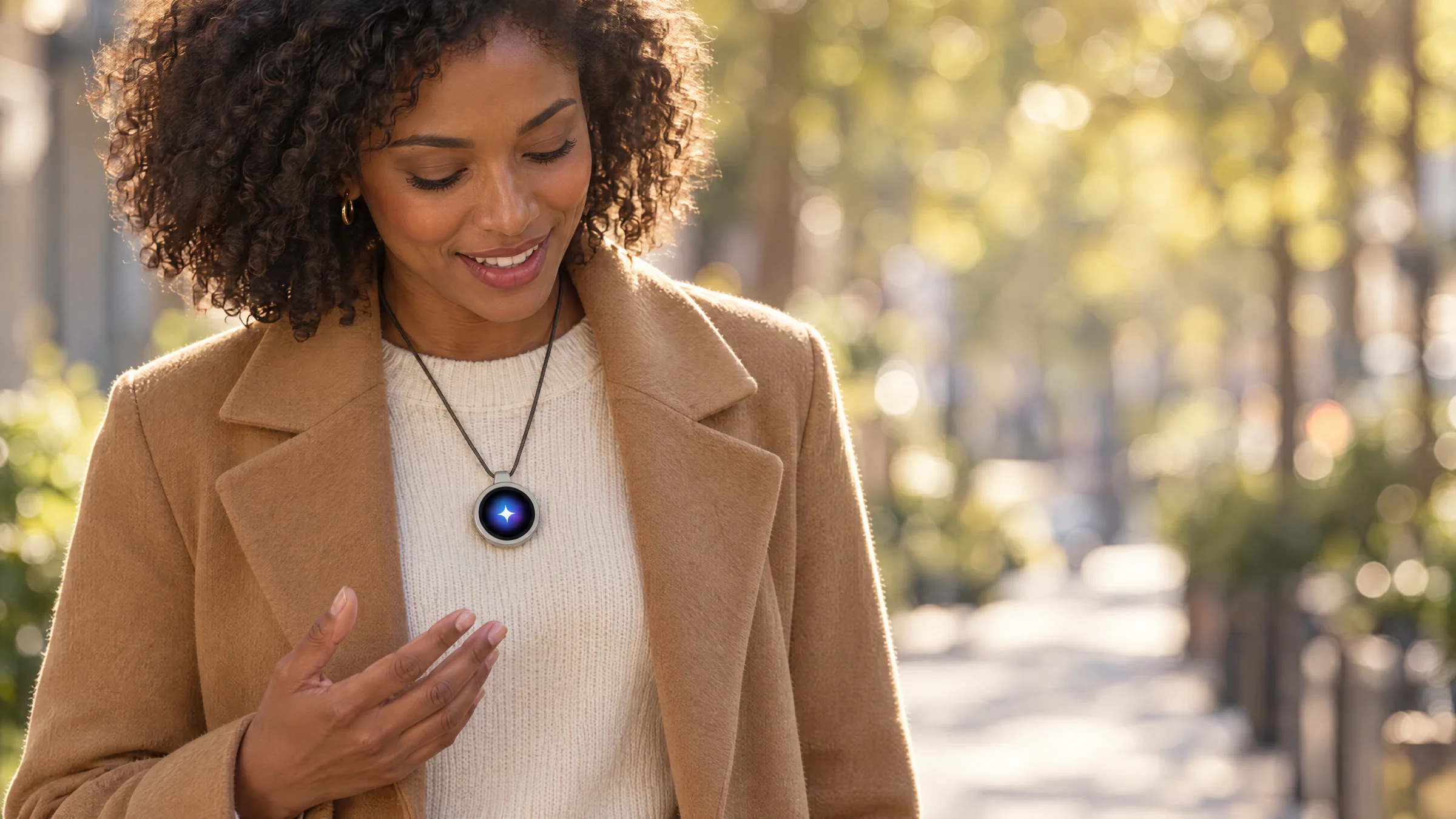 A woman on a city street in the morning, smiling as she talks to metaterrAI One on a cord around her neck